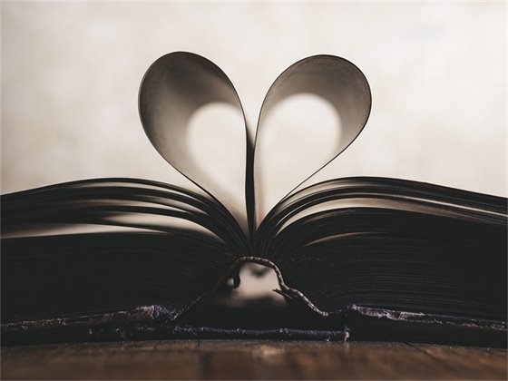 Open book with pages curled back in a heart shape.