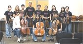Teens holding stringed instruments.