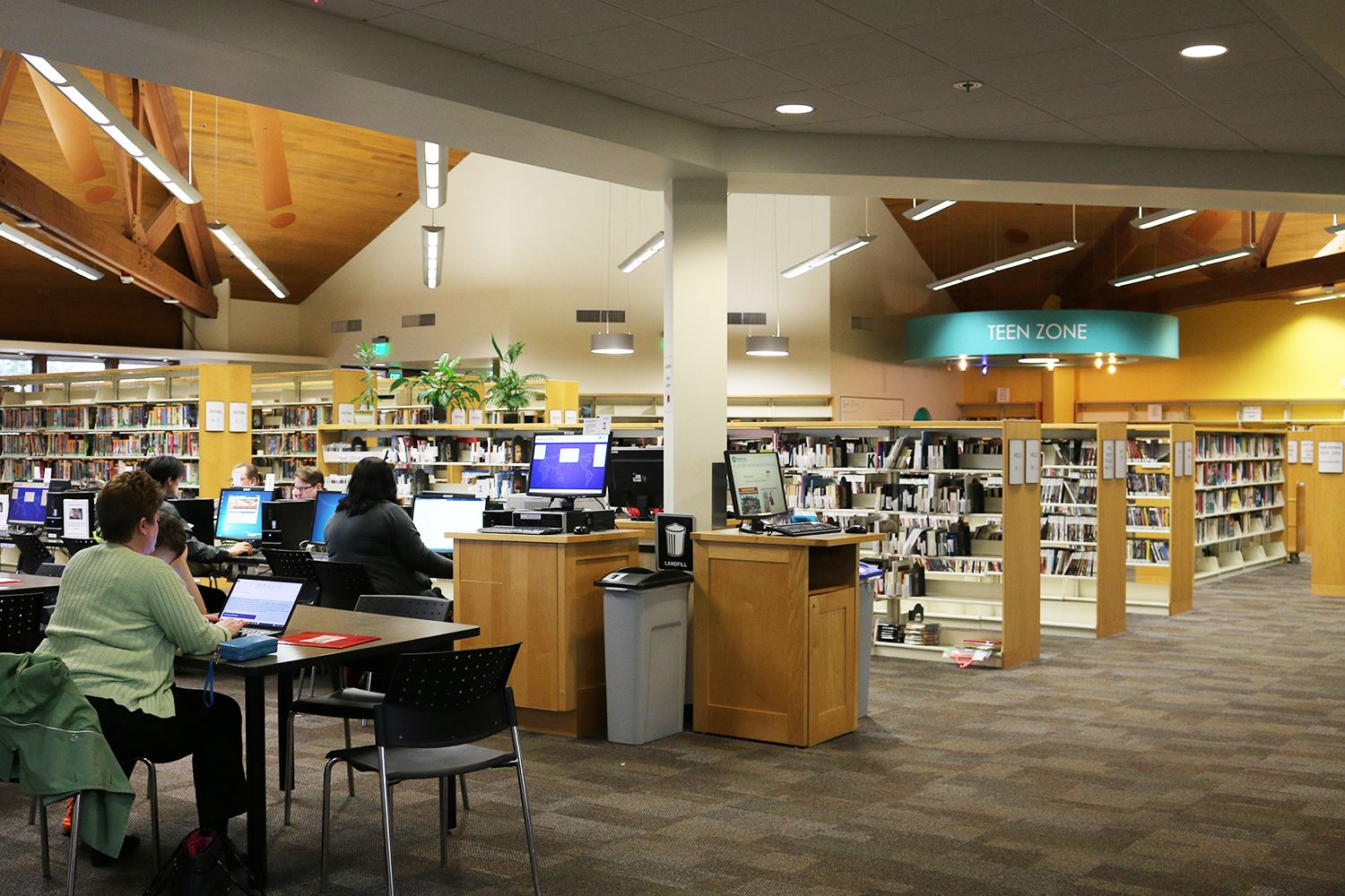 Photo of the inside of a library building with people using computers.