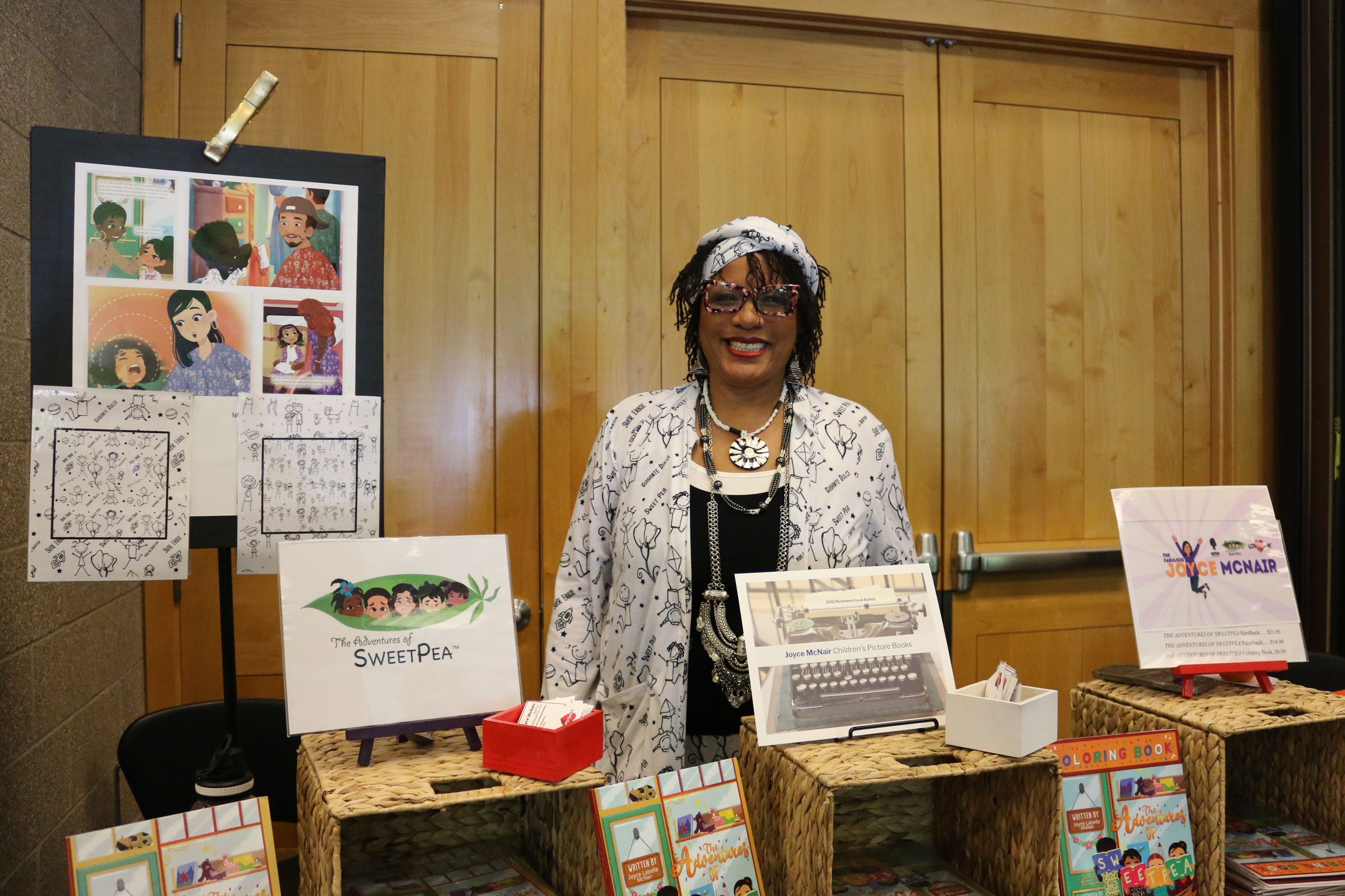 Photo of person standing behind a table with books on display.